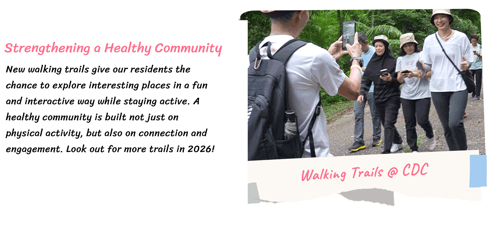 A group of people walking on a park trail, with one person taking photos on a smartphone.
